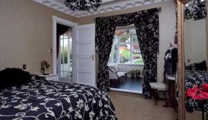 a bedroom with a bed and a mirror and a window at Te Aroha维多利亚度假屋 in Te Aroha