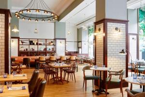 un restaurant avec des tables et des chaises ainsi qu'un bar dans l'établissement London Marriott Hotel Marble Arch, à Londres
