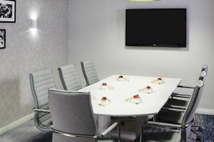 a conference room with a white table and chairs at London Marriott Hotel Marble Arch in London