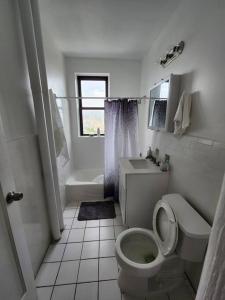 a white bathroom with a toilet and a sink at Elegant 2 bed gem! mins from NYC in Union City