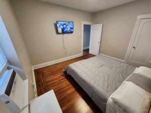 1 dormitorio con 1 cama y TV de pantalla plana en Elegant 2 bed gem! mins from NYC en Union City