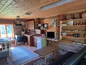 a kitchen in a log cabin with a refrigerator and a table at Guesthouse Nature Trails Sweden 