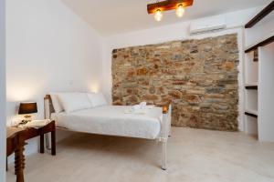 a bedroom with a bed and a stone wall at Michael's apartment Filoti in Philotium