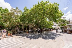 a street with trees and people sitting outside a building at Michael's apartment Filoti in Philotium