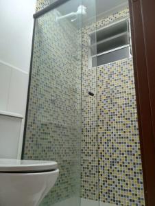 a bathroom with a glass shower with a toilet at Resiliência House in João Pessoa