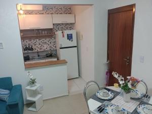 a kitchen with a table and a white refrigerator at Resiliência House in João Pessoa
