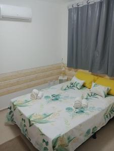 um quarto com uma cama grande com lençóis azuis e brancos em Resiliência House em João Pessoa