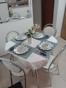 uma mesa de jantar com cadeiras e pratos em Resiliência House em João Pessoa