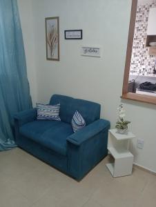 a blue couch sitting in a living room at Resiliência House in João Pessoa