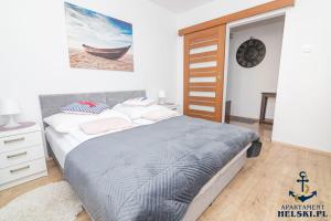 a bedroom with a bed and a clock on the wall at Apartament Helski in Hel