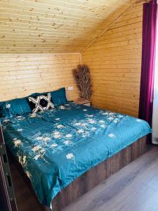1 dormitorio con cama azul y pared de madera en Cabana Amelie Baile Figa, en Beclean