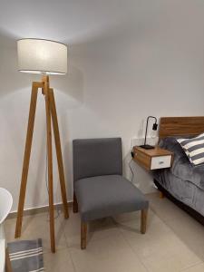 um quarto com uma cadeira, um candeeiro e uma cama em Soler Premium em Buenos Aires