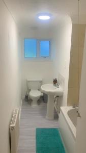 La salle de bains est pourvue de toilettes, d'un lavabo et d'une baignoire. dans l'établissement Aqua Suite, à Gillingham