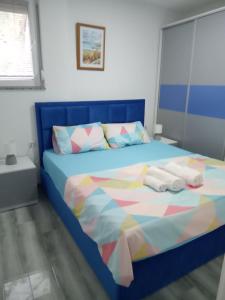 - une chambre avec un lit bleu et des serviettes dans l'établissement Anabela Apartment, à Ohrid