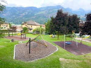 un parco giochi con altalene in un parco con montagne di Appartamento Litegosa a Panchia