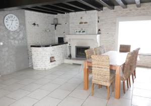 a dining room with a table and a fireplace at Gites la Marquise in Prisse-la-Charriere