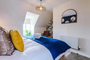 Schlafzimmer mit einem blauen und weißen Bett und einem Spiegel in der Unterkunft Newly Refurbished 3 Double Bedroom Knowsley Liverpool Townhouse in Knowsley