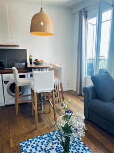 ein Wohnzimmer mit einem Tisch und einem blauen Sofa in der Unterkunft Joli T2 avec balcon au Cours Julien in Marseille