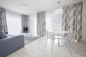 un soggiorno con tavolo, sedie e divano di VacationClub - Bormio Apartament 5 a Sienna