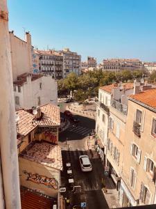 einen Luftblick auf eine Stadtstraße mit Gebäuden in der Unterkunft Joli T2 avec balcon au Cours Julien in Marseille