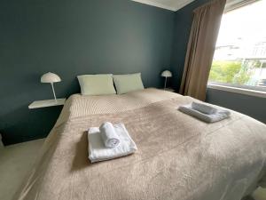 a bedroom with a large bed with towels on it at Leknes City Apartment in Leknes