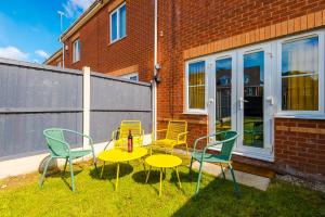a group of chairs and a table in a yard at Newly Refurbished 3 Double Bedroom Knowsley Liverpool Townhouse in Knowsley