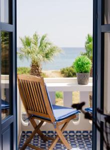 a rocking chair on a porch with a view of the ocean at RODAVGI APARTMENTS in Andros