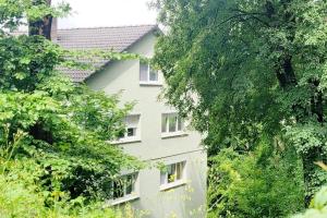 a white building with white windows and trees at Am Wald in Waldkirch