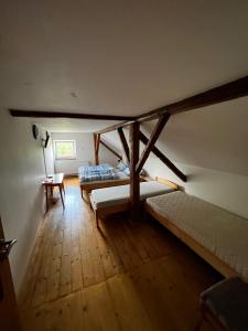 an attic room with two beds and a table at Penzion Za potokem in Nová Pec +7 photos