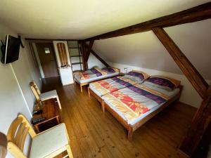 a room with two beds in a attic at Penzion Za potokem in Nová Pec