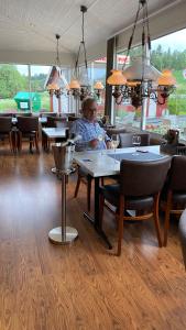 een man aan een tafel in een restaurant bij Gullvåg Camping Nyberg in Soknedal