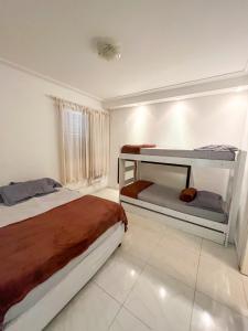 - une chambre avec 2 lits superposés et une fenêtre dans l'établissement Apartamento com Varanda e Suíte Enseada Guarujá, à Guarujá