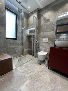une salle de bain avec une douche, des toilettes et un lavabo dans l'établissement Fox Apartments, à Tirana