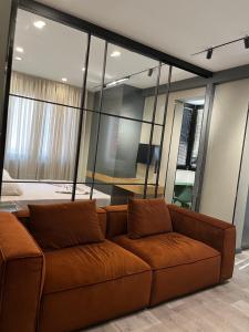- un canapé brun dans une chambre dans l'établissement Fox Apartments, à Tirana