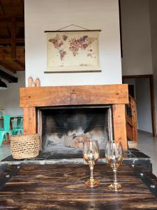 zwei Weingläser auf einem Tisch vor einem Kamin in der Unterkunft La casita de LOS CERROS DE SMA in San Martín de los Andes