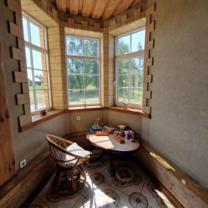 a small room with a table and two windows at Vesta in Dolnāja