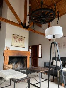 ein Wohnzimmer mit einem Kamin und einem Kronleuchter in der Unterkunft La casita de LOS CERROS DE SMA in San Martín de los Andes