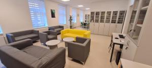 una sala de espera con sofás y una silla amarilla en Zagreb budget rooms, en Zagreb