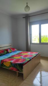 a bedroom with a bed with a colorful quilt on it at Guesthouse Isolde in Vlorë