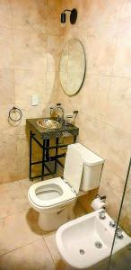 La salle de bains est pourvue de toilettes, d'un lavabo et d'un miroir. dans l'établissement Alsina Suite!! Hermoso y moderno apart en Salta!!, à Salta