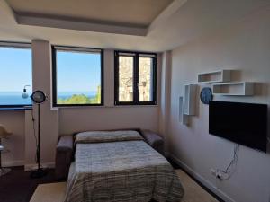 una camera con 2 letti e una TV a schermo piatto di The White Domus a Taormina