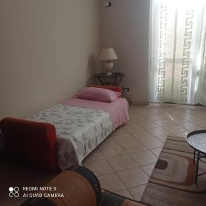 Dormitorio pequeño con cama y mesa en Vacanze siciliane, en Fiumefreddo di Sicilia