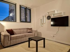 a living room with a couch and a flat screen tv at The White Domus in Taormina