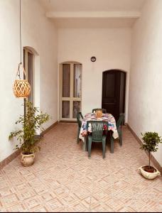un patio con mesa, sillas y plantas en Vacanze siciliane, en Fiumefreddo di Sicilia