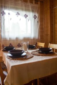 una mesa con platos y cuencos con una ventana en Domki u Bukowskich en Jezierzany