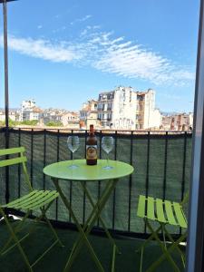 einen Tisch mit zwei Weingläsern und einer Flasche auf dem Balkon in der Unterkunft Joli T2 avec balcon au Cours Julien in Marseille