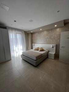 a bedroom with a bed and a large window at B&B VIRGILIO LAMEZIA AIRPORT in SantʼEufemia Lamezia