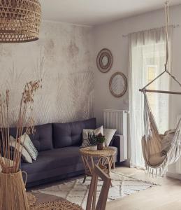 ein Wohnzimmer mit einem blauen Sofa und einem Tisch in der Unterkunft Apartament&SPA Lis&Las in Sobótka
