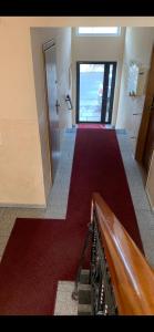 an empty hallway with a red carpet and a door at Apartamenty Firfas Rodzinny 11 in Bydgoszcz