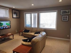 a living room with a couch and a flat screen tv at Spacious One Bedroom Walkout Basement Suite in Calgary